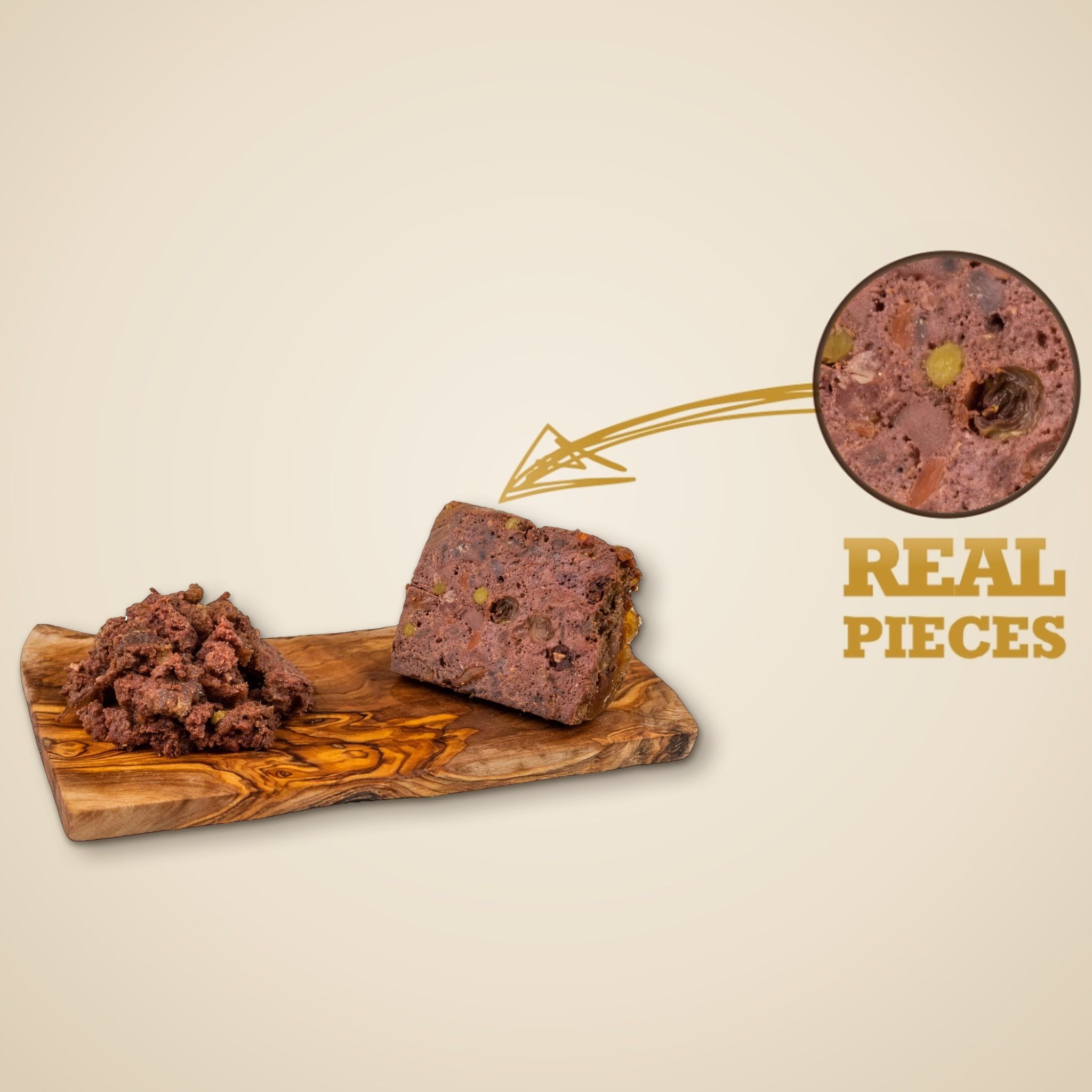 Obsah konzervy Kangaroo with Cranberries na dřevěném prkénku, v kruhu zvětšený řez s kousky masa a zeleniny a nápis „Real Pieces“