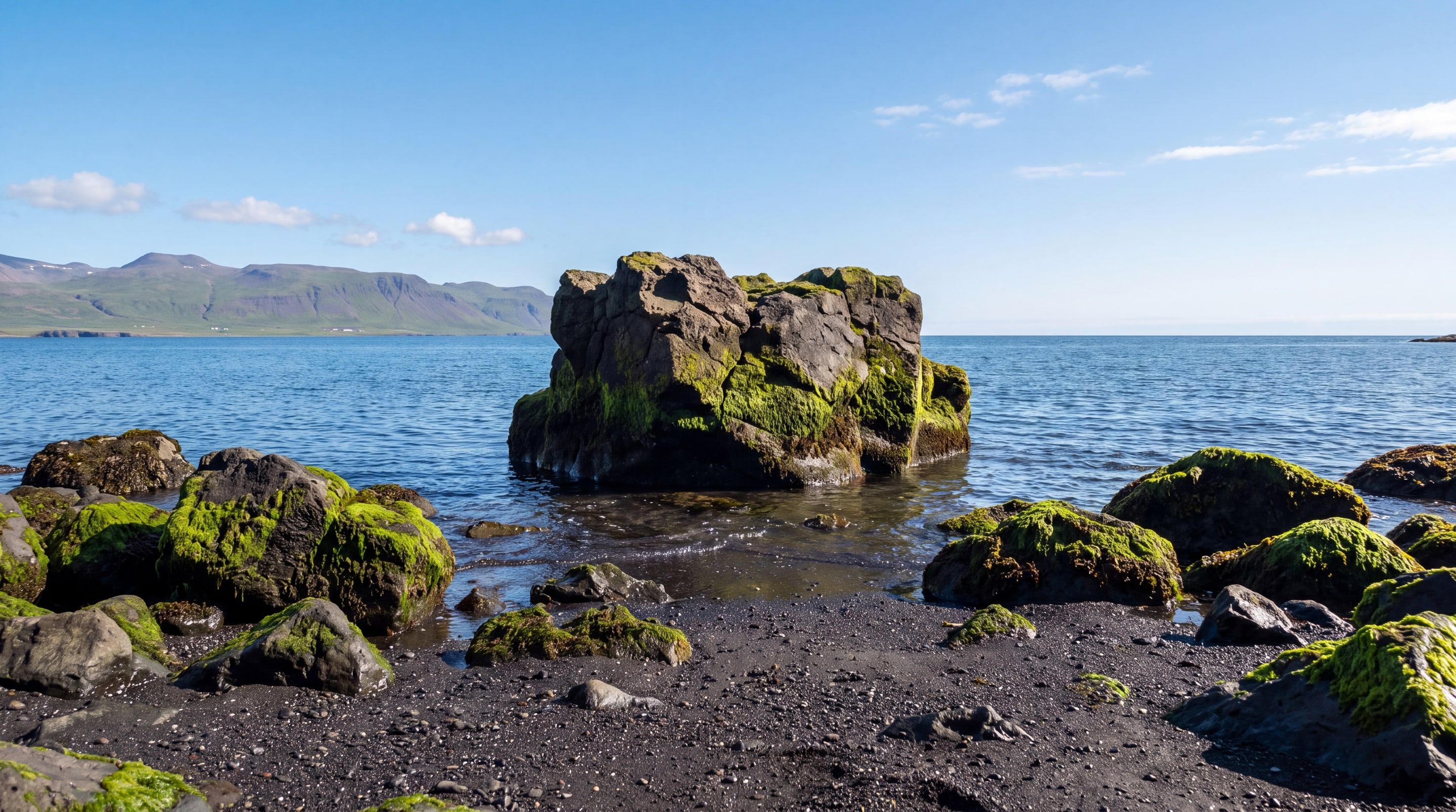 Černá sopečná pláž na Islandu a čedičová skála porostlá mechem